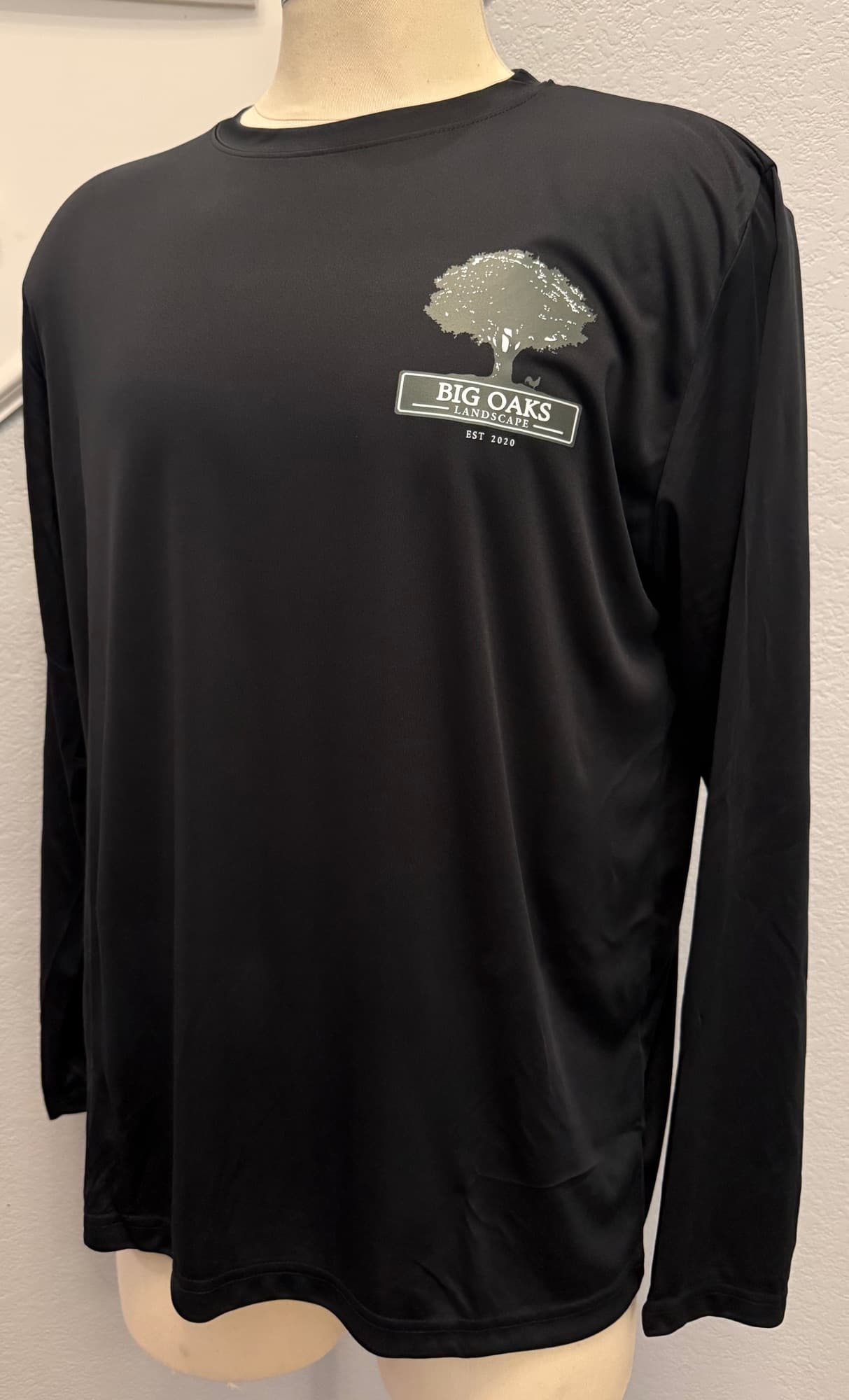 Black performance long-sleeve with the Big Oaks Landscape tree logo printed on the chest